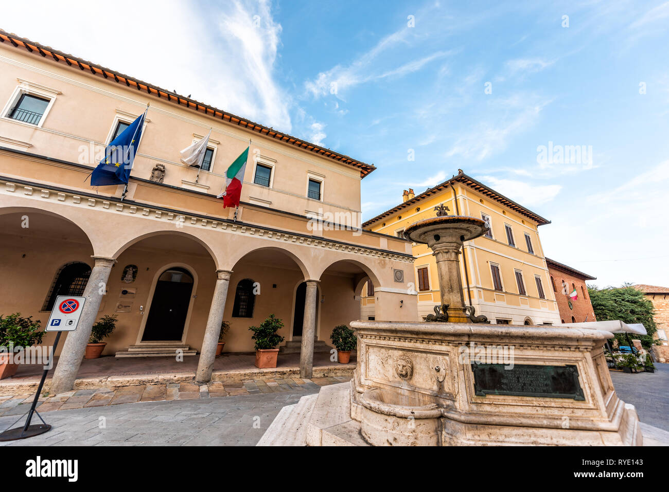 Chiusi, Italien - 25 August 2018: leere Straße in kleinen Stadt Dorf in der Toskana bei Tag mit Rathaus Flaggen im Zentrum und historischen Brunnen Stockfoto