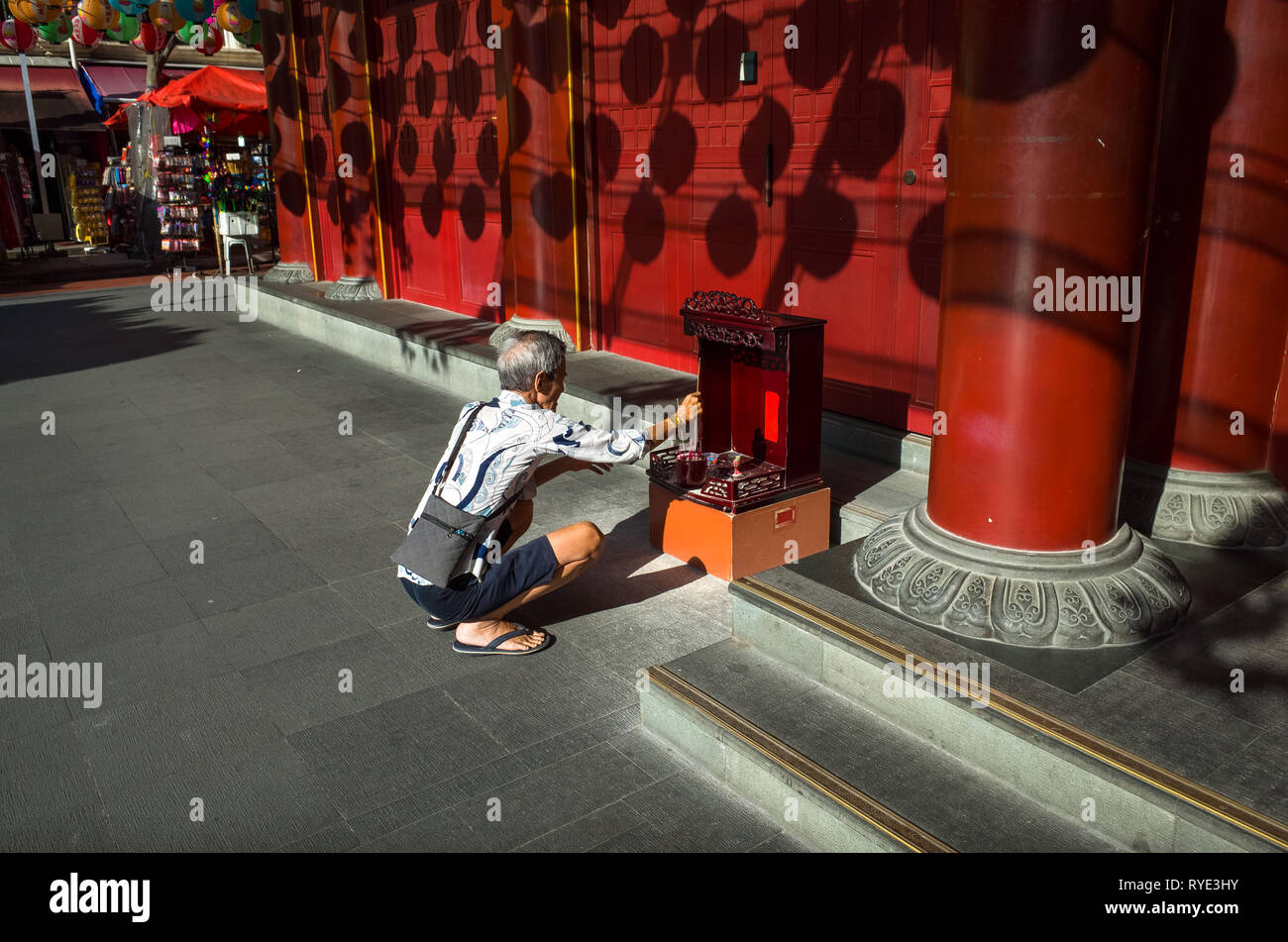 Alter Mann am Altar vor dem Buddha Zahns Museum - Chinatown, Singapur beten Stockfoto