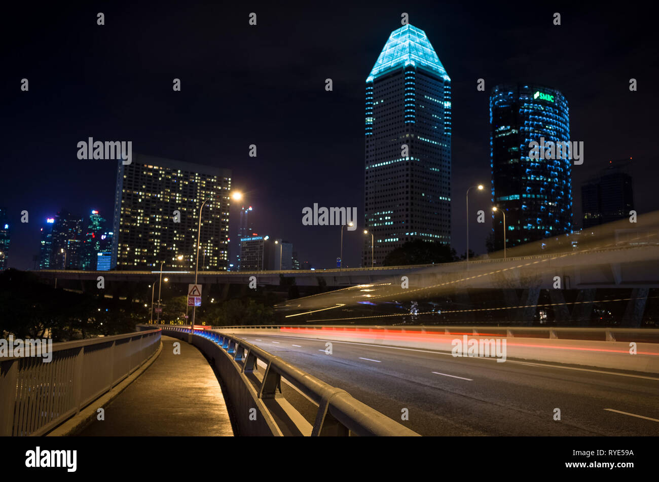Lange Belichtung Auto Verkehr auf Straße und Singapur Wolkenkratzer in der Nacht Stockfoto