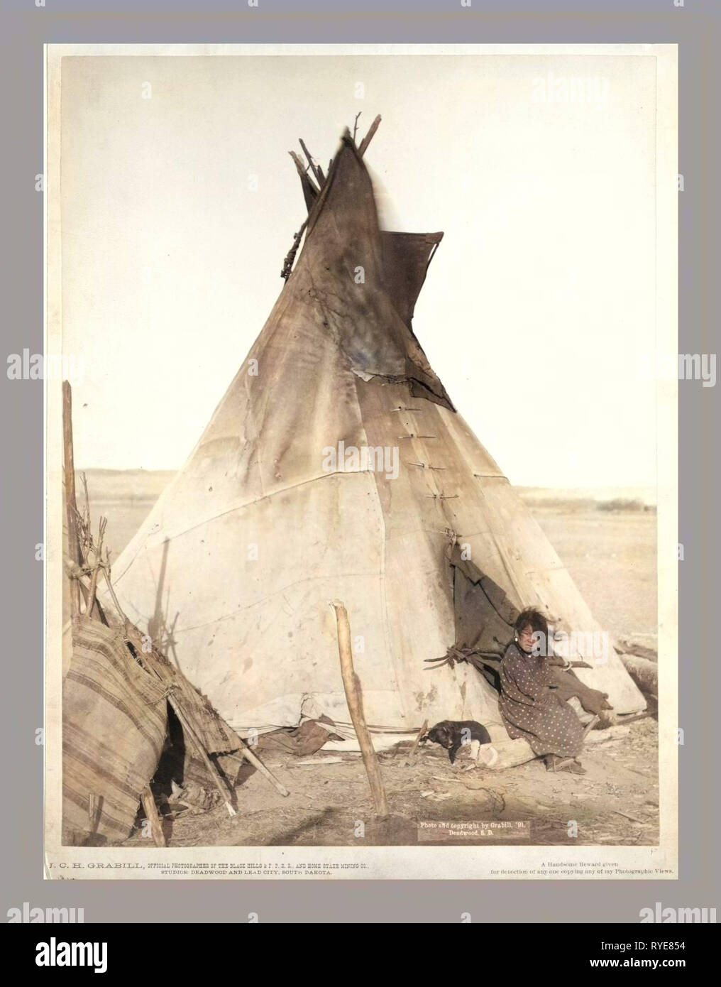 Eine junge oglala Mädchen sitzt vor einem Tipi, mit einem Welpen neben Ihr, vermutlich auf oder in der Nähe von Pine Ridge Reservat Stockfoto