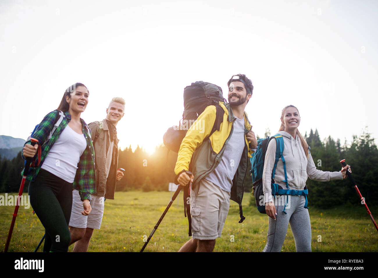 Gruppe der Wanderer mit Rucksack und Stöcke zu Fuß auf den Berg. Freunde machen einen Ausflug Stockfoto