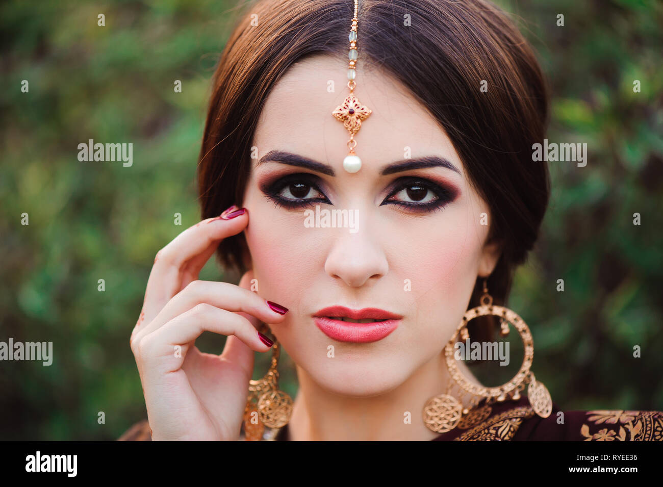 Schönen jungen kaukasischen Frau in traditioneller indischer Kleidung sari mit Braut Make-up und Schmuck und Henna Tattoo auf Händen Stockfoto