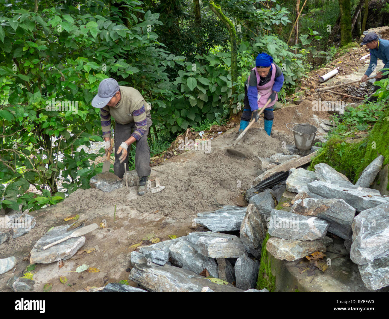 Die manuelle Arbeit Straßenbau in der Nähe von Duoyishu Dorf, Yuanyang Grafschaft, in der Präfektur Honghe in der südöstlichen Provinz Yunnan, China, Stockfoto