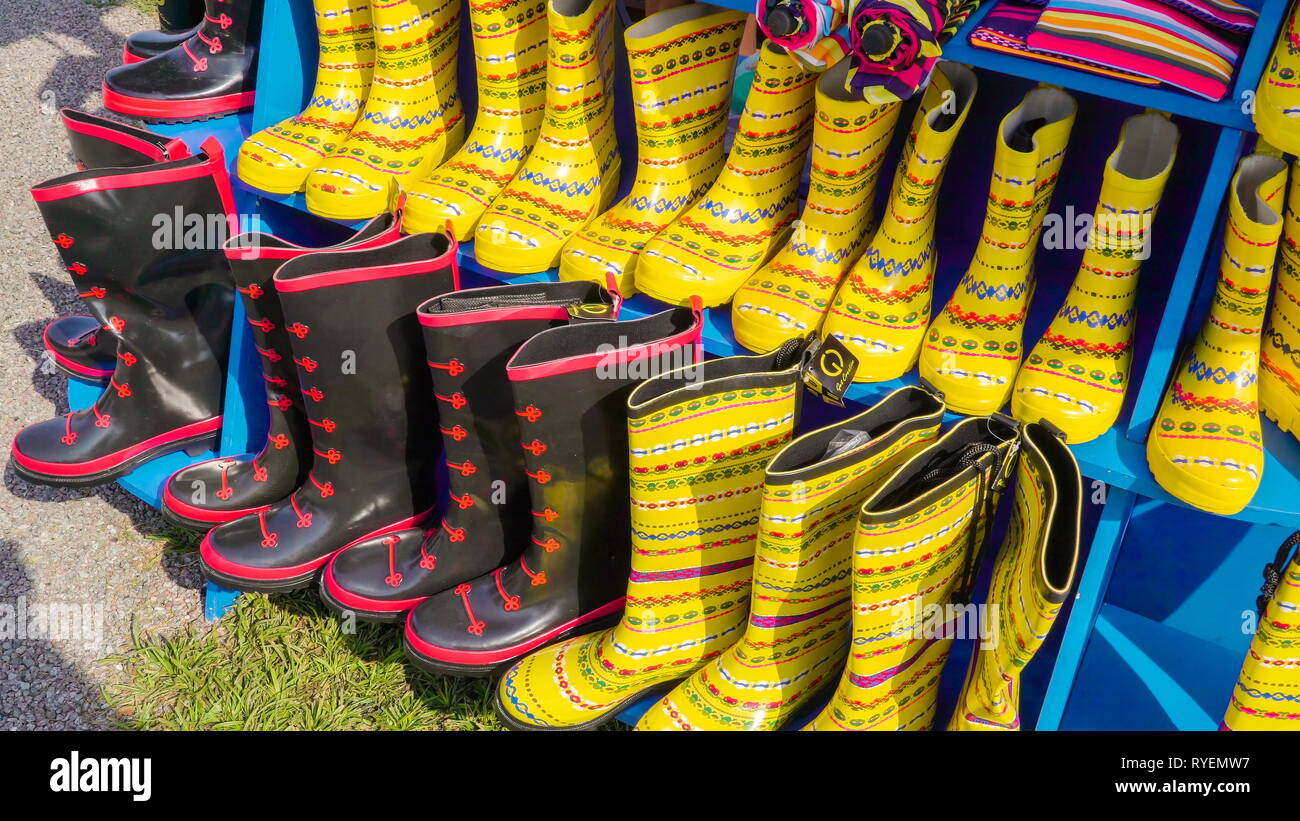 Gelbe und schwarze Stiefel auf dem Regal ausserhalb des Parks in der Stadt Stockfoto