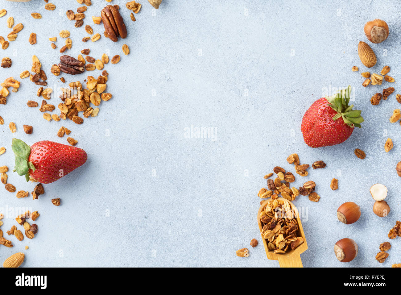 Müsli, Erdbeeren und Zutaten - Hafer, verschiedene Nüsse und Honig. Gesundes Frühstück Hintergrund mit kopieren. Stockfoto