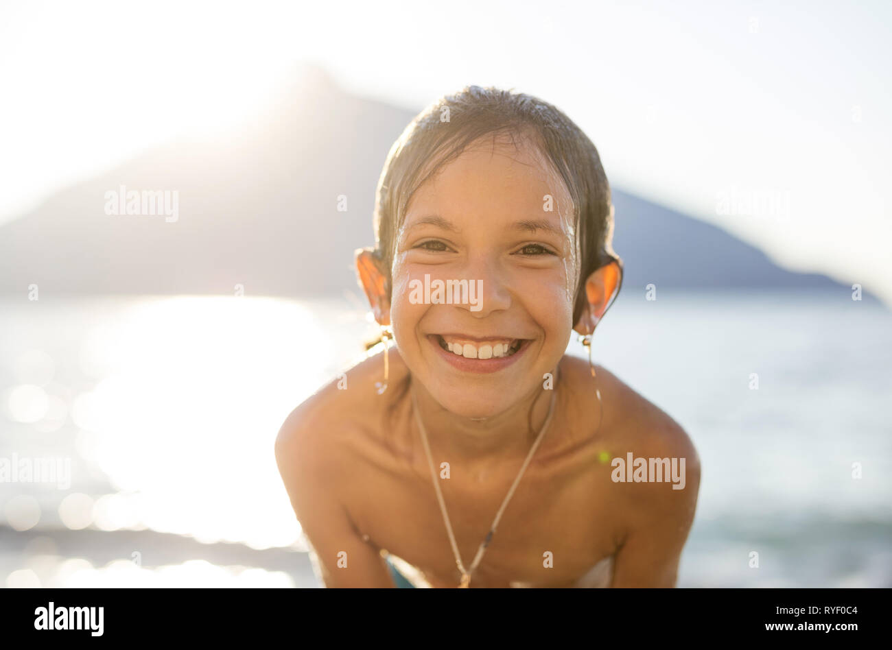 Porträt der Glückliche junge Mädchen am Strand bei Sonnenuntergang Stockfoto