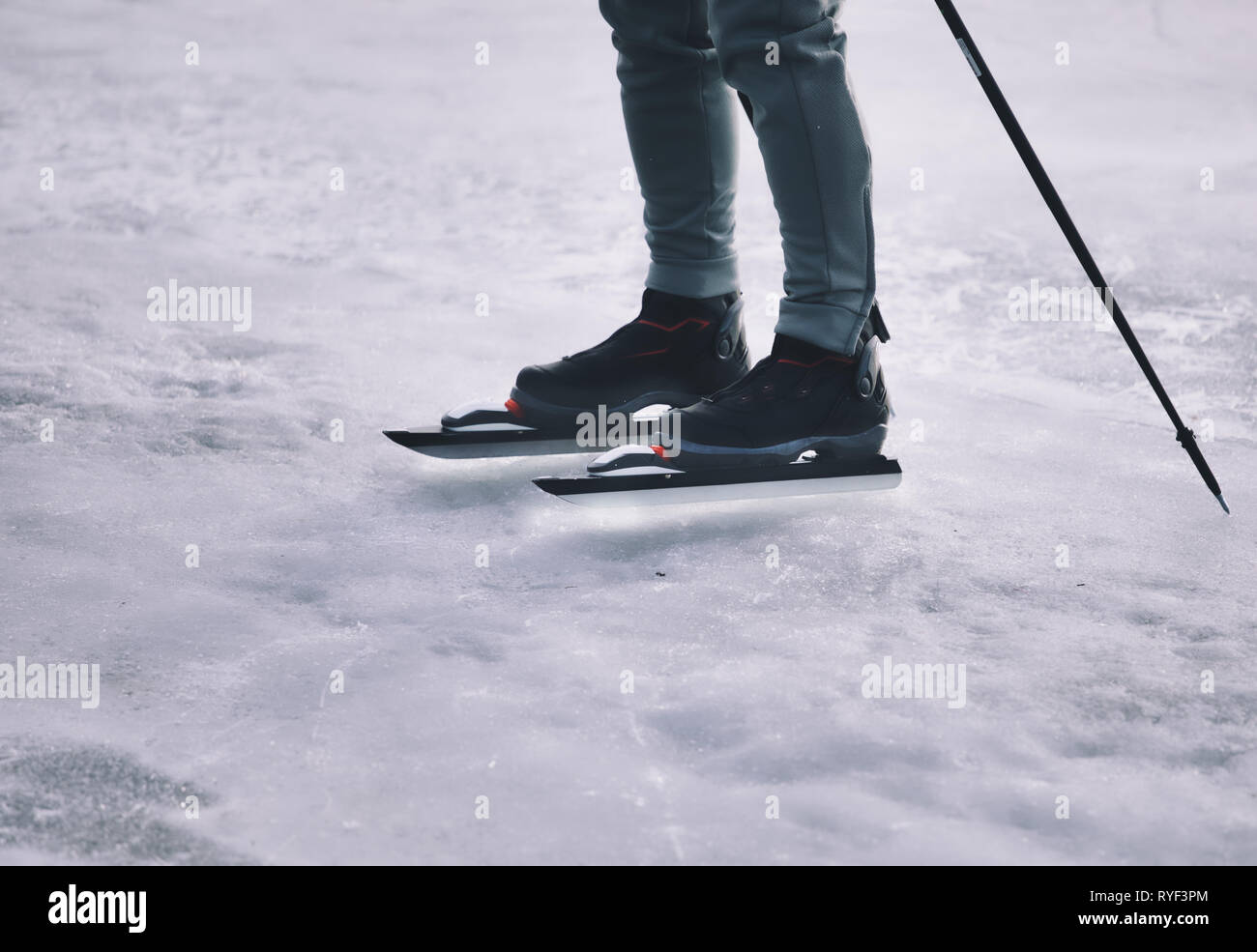 Füße und Beine der Fernverkehr ice Skater mit Eis Pole stehen auf See Malaren, Schweden, Skandinavien Stockfoto