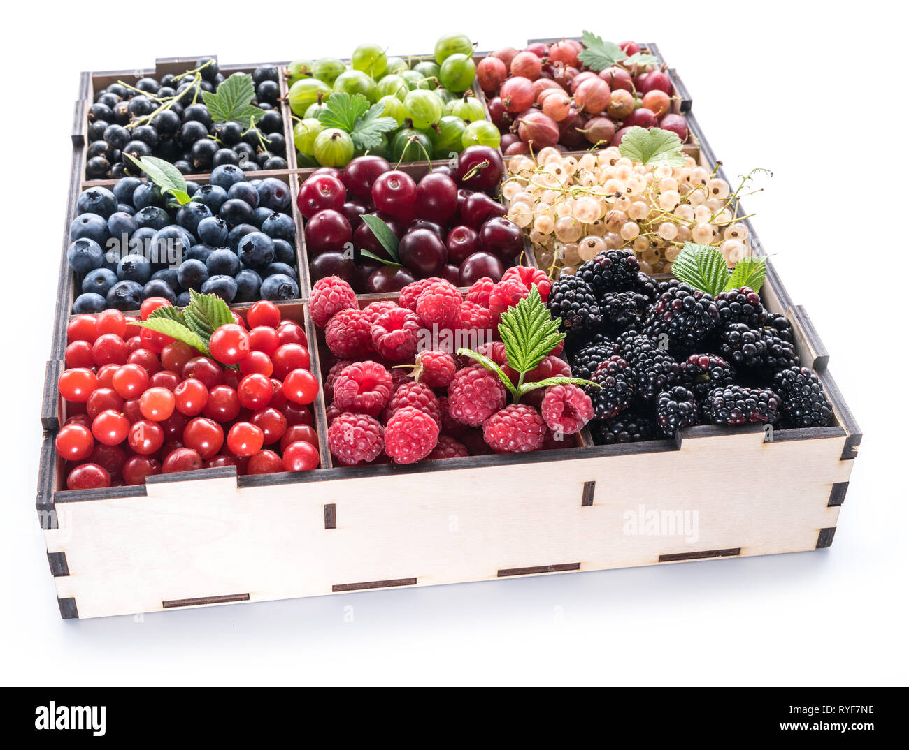 Bunte Beeren in der Holzkiste auf weißem Hintergrund. Ansicht von oben. Stockfoto