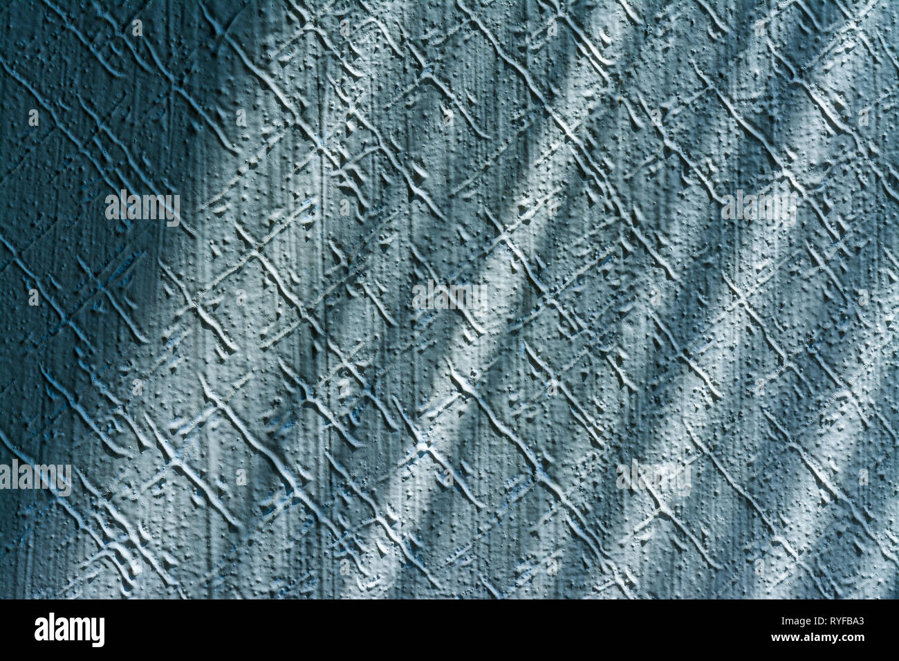 Angenehme Textur Detail riefen Stuck Gips. Innenraum close-up. Blaue geprägte Wand leuchtet durch Sonnenlicht. Verspielte diagonal Schatten. Retro Hintergrund. Stockfoto