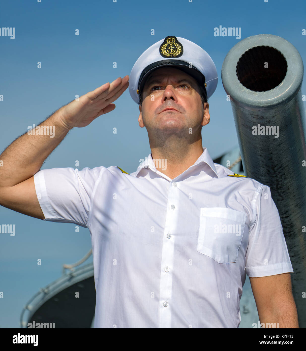 Ein Navy Officer stehen unter der Kanone und würdigen. Der Kapitän in