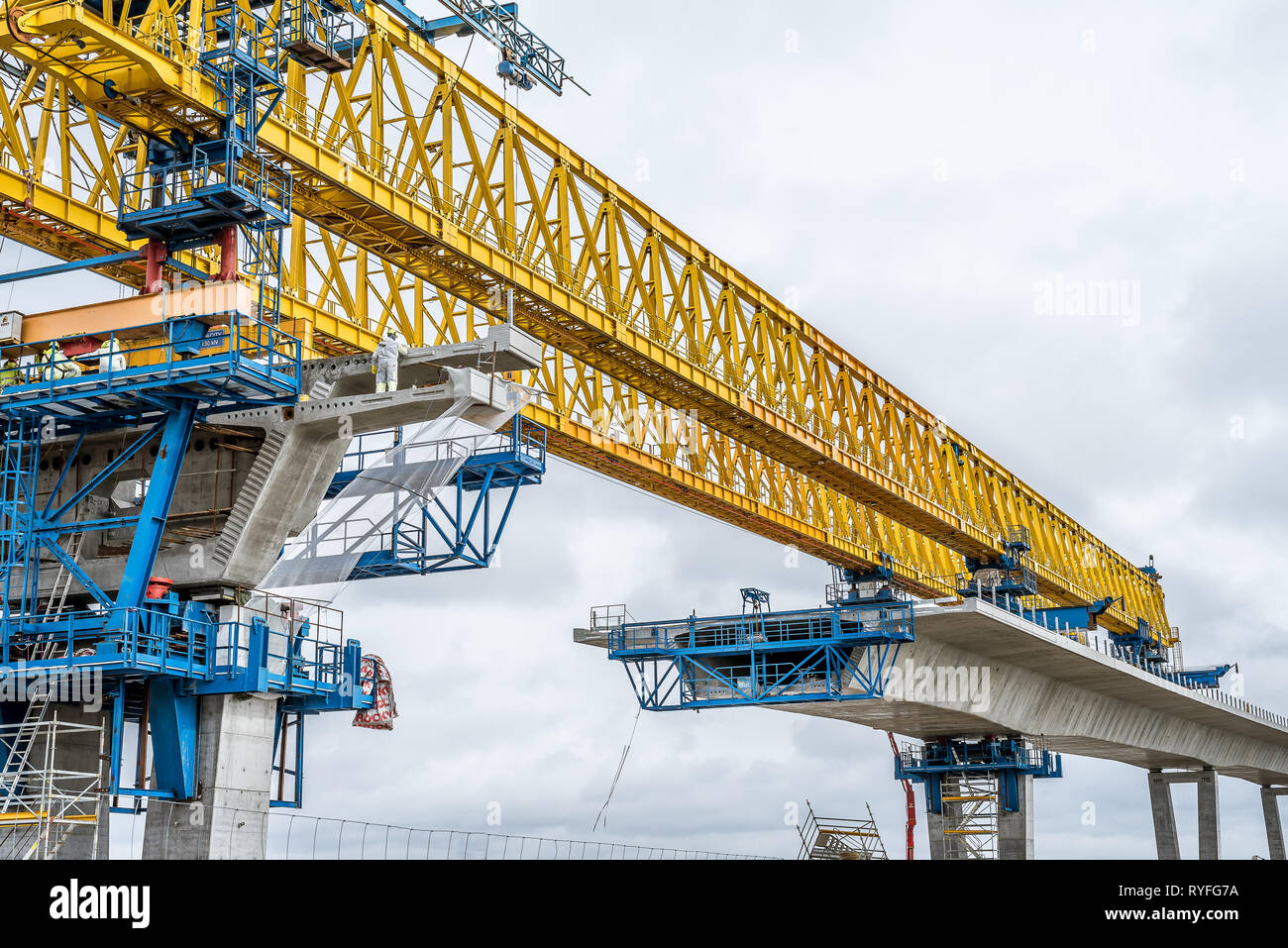 Granitblock verkleben Elemente aus Beton auf der Baustelle einer neuen Brücke über den Roskilde Firth, mit einem riesigen gelben Kran. Frederikssund, D Stockfoto