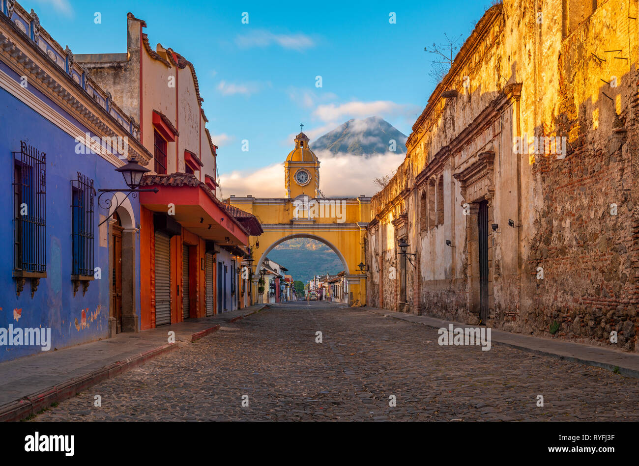 Stadtbild von Antigua bei Sonnenaufgang mit kolonialen Architektur und den gelben Santa Catalina Bogen mit den Agua Vulkan im Hintergrund, Guatemala. Stockfoto