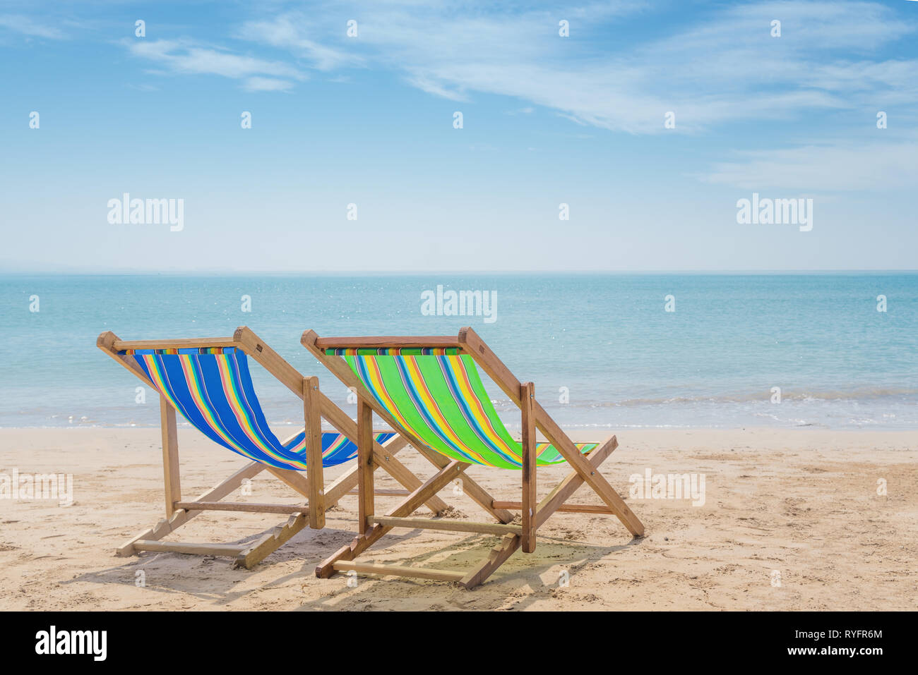 Zwei Liegen auf dem weißen Sand mit blauem Himmel und Sommer Meer Hintergrund. Sommer, Ferien, Reisen und Urlaub. Stockfoto Zwei Liegen auf dem weißen Sand mit blauem Himmel und Sommer Meer Hintergrund. Sommer, Ferien, Reisen und Urlaub. Stockfoto