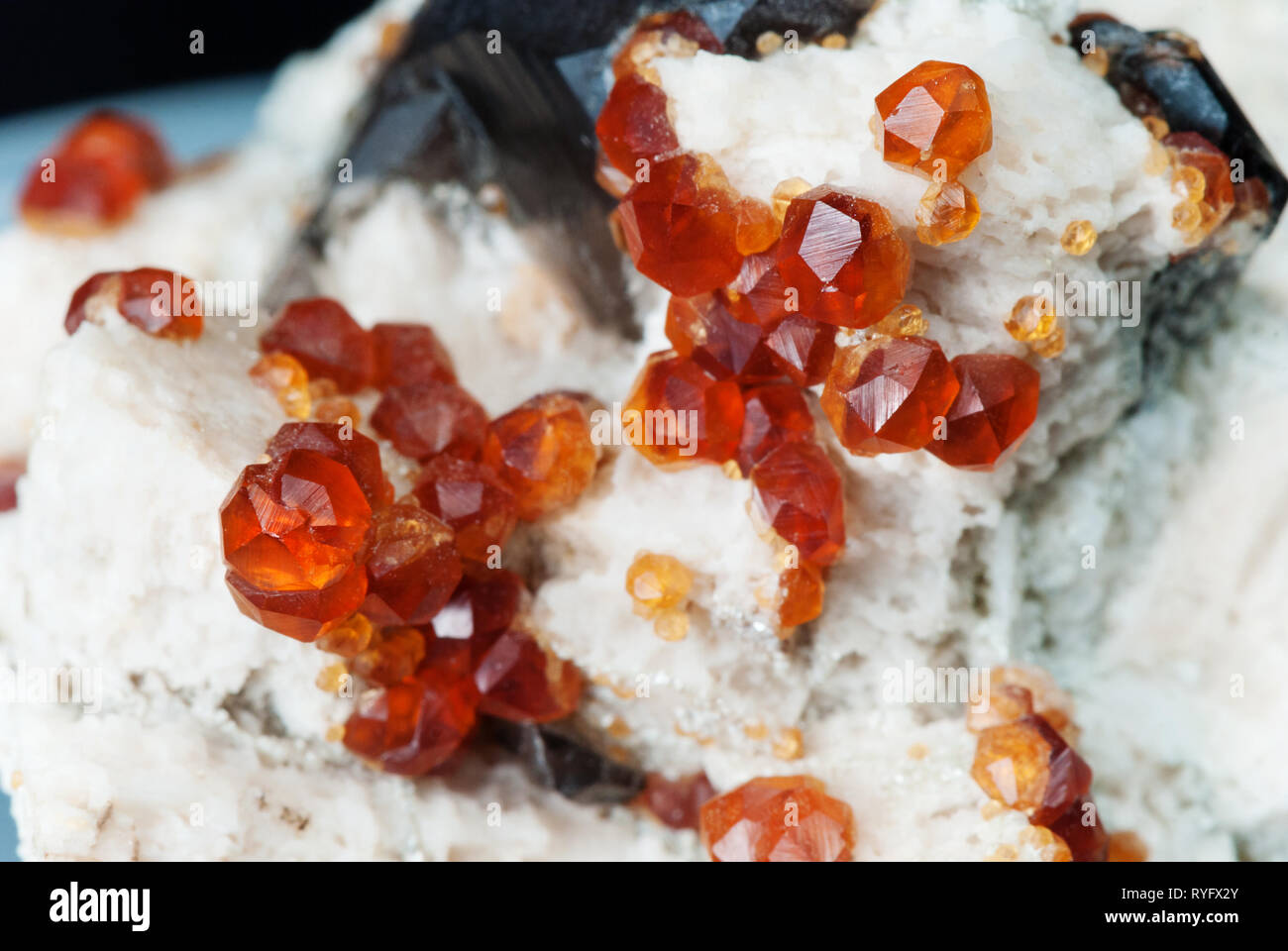 Schöne transparente Rohkristalle von Orange spessartite garnet Edelstein aus China in Matrix Stockfoto