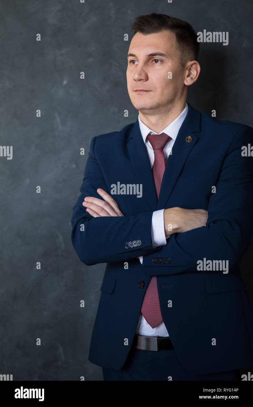 Porträt der jungen intelligenten mann Rechtsanwalt stand mit verschränkten Armen in der modernen Bürogebäude Innenraum, erfolgreichen männlichen Mitarbeiter der Bank gekleidet in Stockfoto