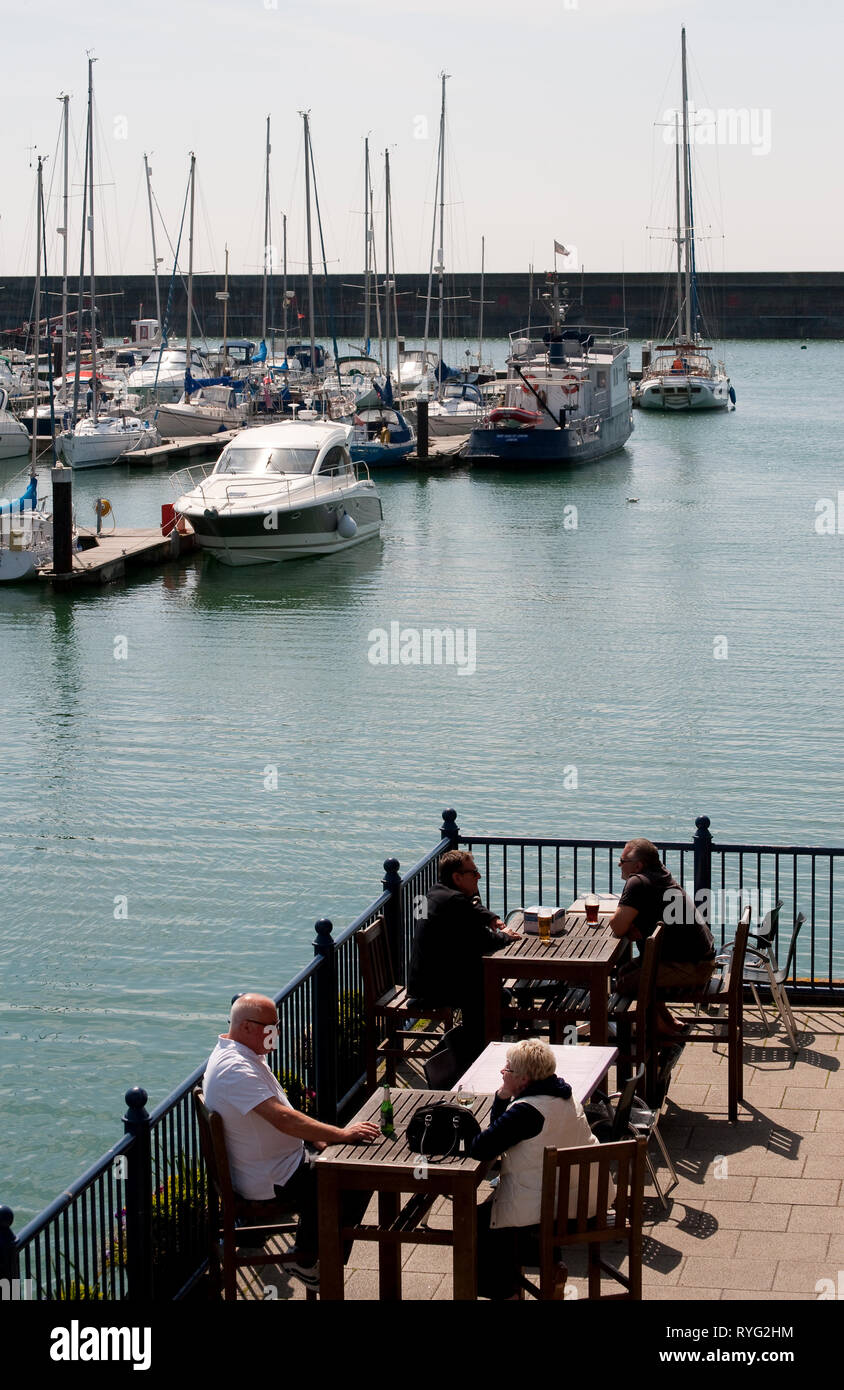 Die Leute draußen sitzen Restaurants in Brighton Marina, Sussex, England. Stockfoto