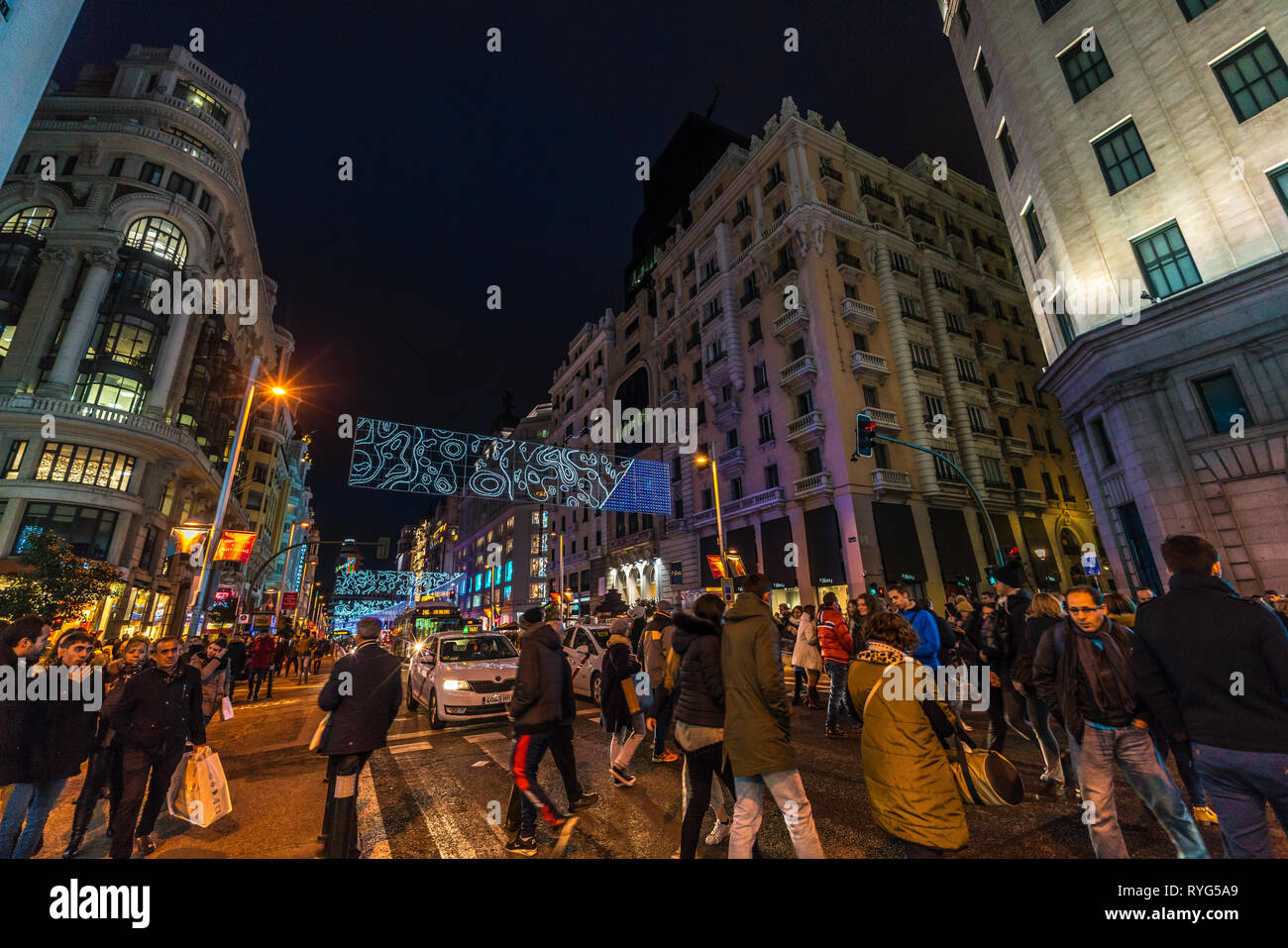 Madrid, Spanien - 26. Dezember 2017: Leute, überfahrt Gran Via Street, geniessen Weihnachtsbeleuchtung Dekoration und Shopping während der Weihnachtszeit. Madrid Stockfoto