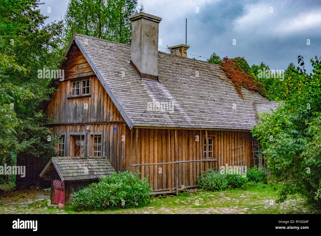 Ländliche Holz- Bauernhof Haus mit Schornstein in die Hügel und Wälder um Suwalki im Nordosten Polens in den späten Sommer. Stockfoto