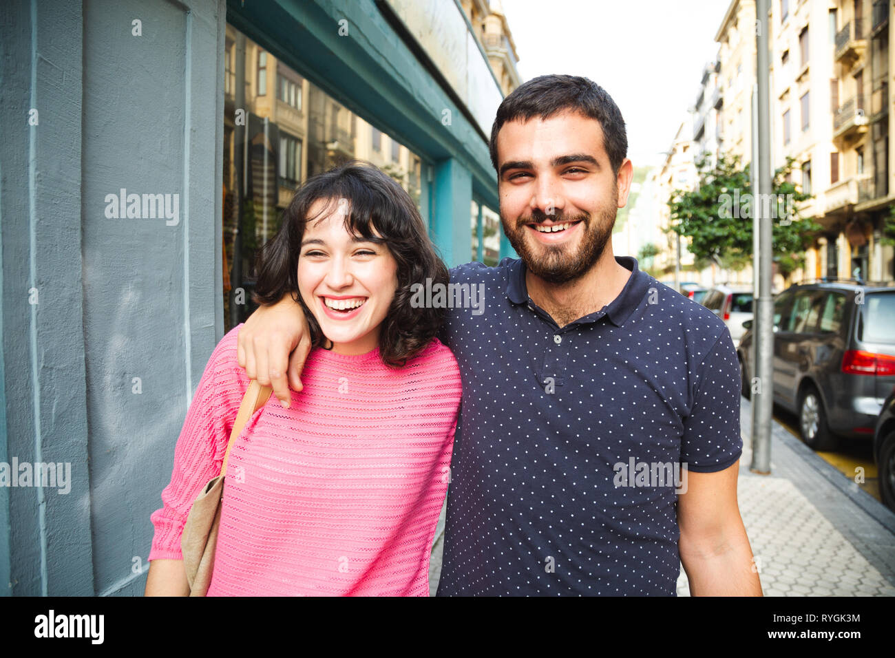 Glücklich und attraktive junge Paar Lachen beim Gehen auf die Straße Stockfoto