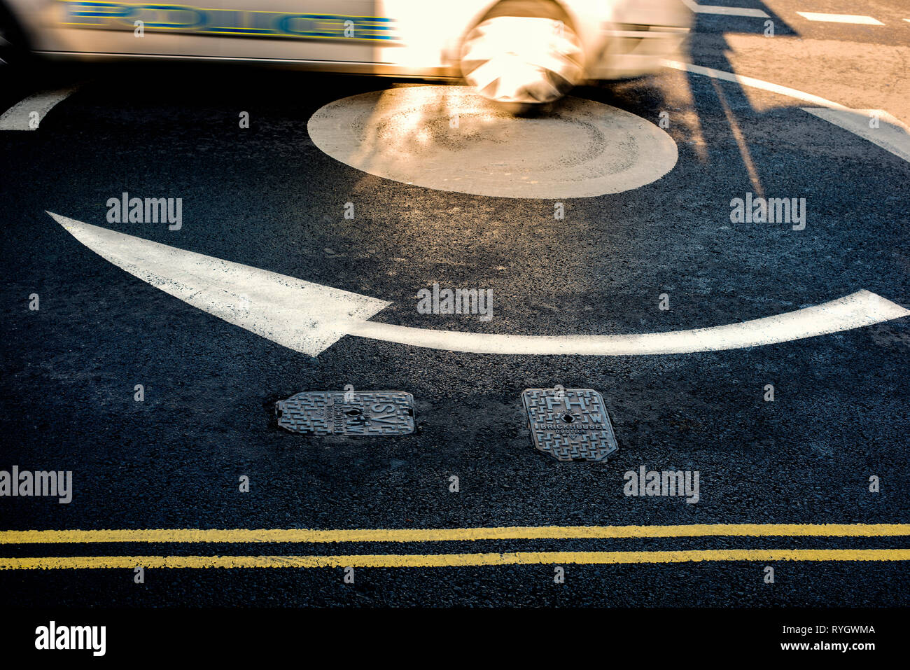 Verschwommen Polizei Auto beschleunigt durch den Kreisverkehr, England, Großbritannien, Großbritannien Stockfoto