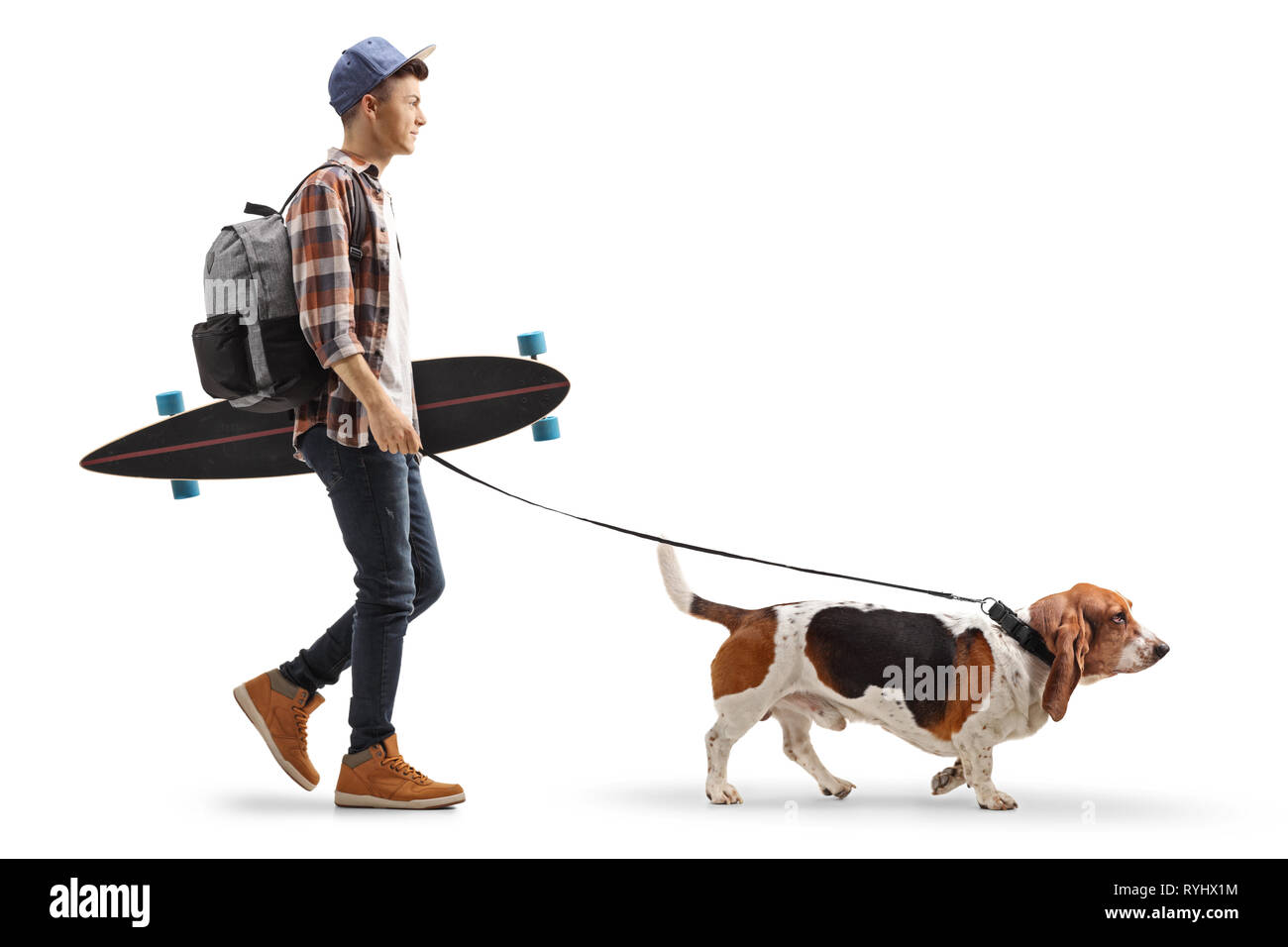 Volle Länge Profil Schuss ein junger Kerl mit einem Rucksack und Longboard walking Basset Hound Dog auf weißem Hintergrund Stockfoto