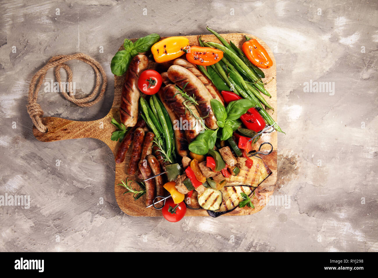 Verschiedene köstliche gegrillte Fleisch mit Gemüse auf einem Grill und gegrilltem Schweinefleisch oder Shish Kebab am Spieß mit Gemüse. Stockfoto