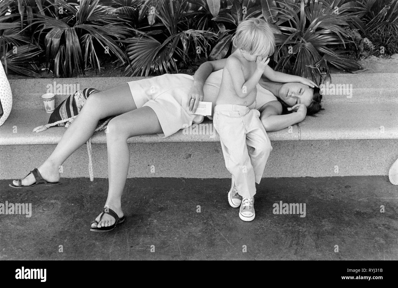 Mutter und Kleinkind erschöpft und müde auf einer Bank liegend Los Angeles California USA 1969 1960er Jahre USA HOMER SYKES Stockfoto