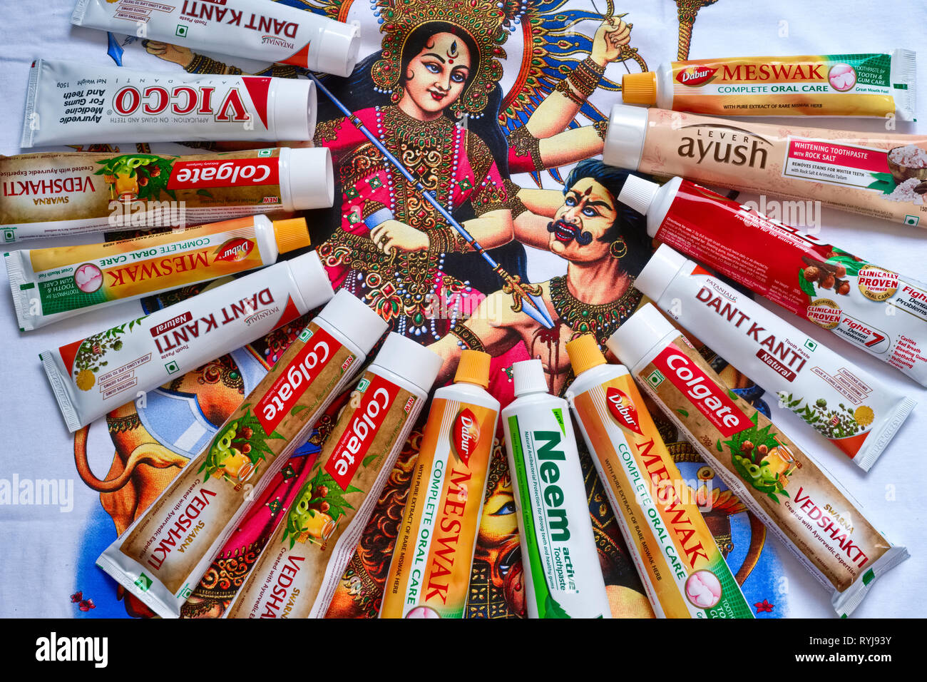Verschiedene Marken der Indischen ayurvedischen Zahnpasten, ausgebreitet auf einem T-Shirt mit einem Hindu mythologischen Stockfoto