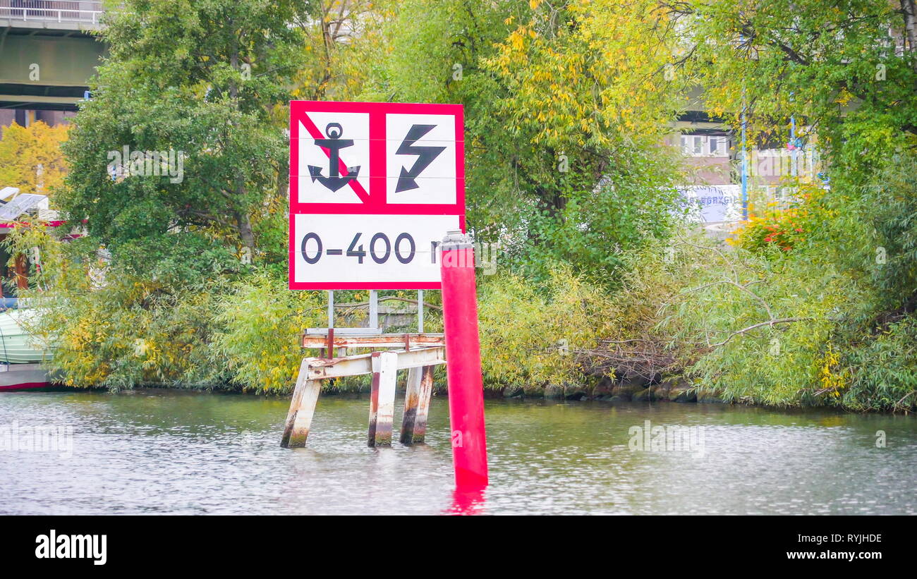 Ein rotes Schild auf dem Meer Wasser in Stockholm Schweden mit dem Wasserspiegel und kein Anker und Blitz Zeichen Stockfoto