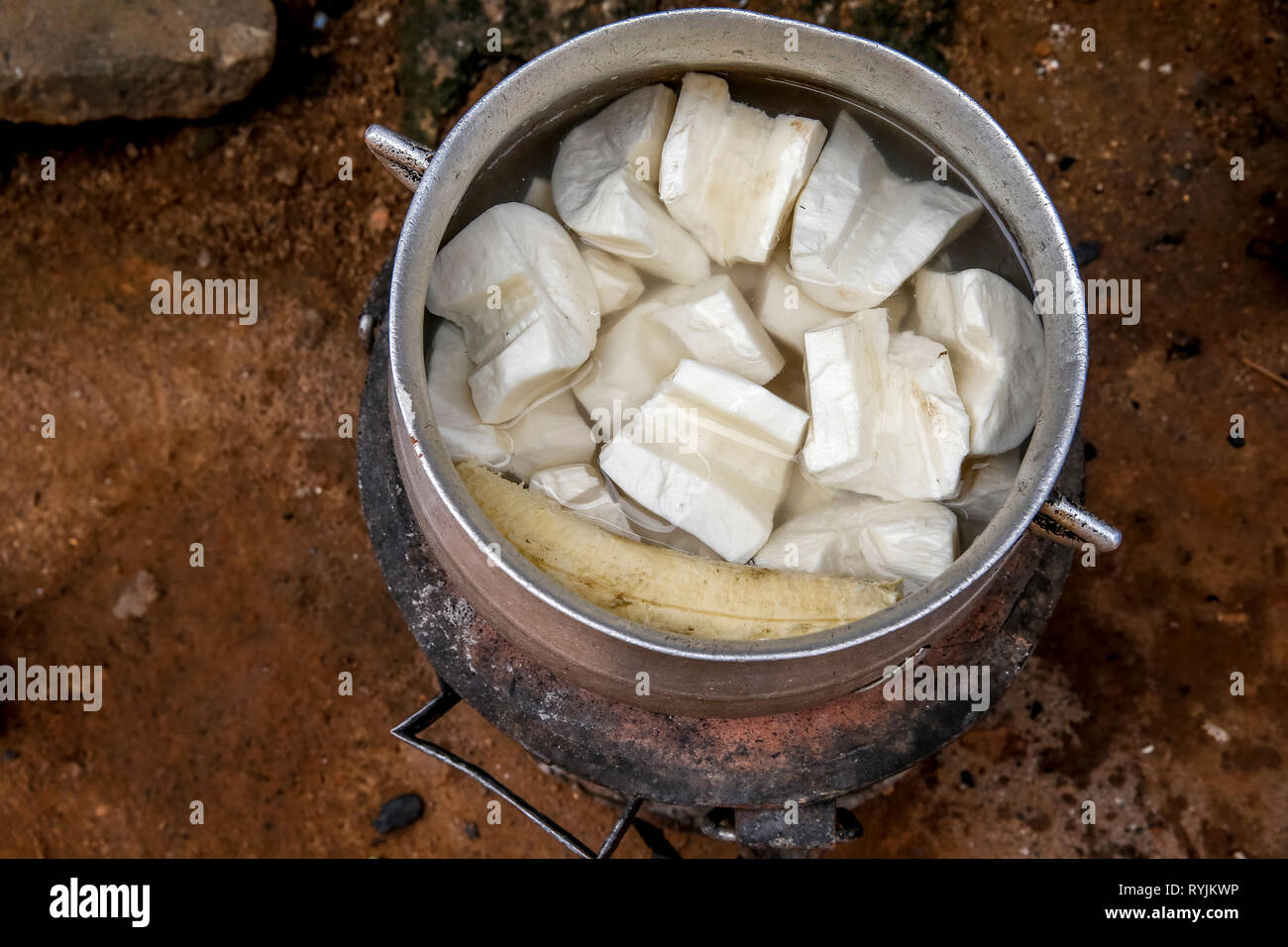 Traditionelles Gericht kochen in einem Dorf in der Nähe von Agboville, Elfenbeinküste. Yamswurzeln gemischt mit wegerich. Stockfoto