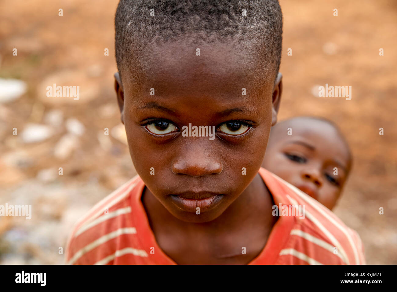 Mädchen, die ihr kleiner Bruder auf dem Rücken in Guezon, Elfenbeinküste. Stockfoto