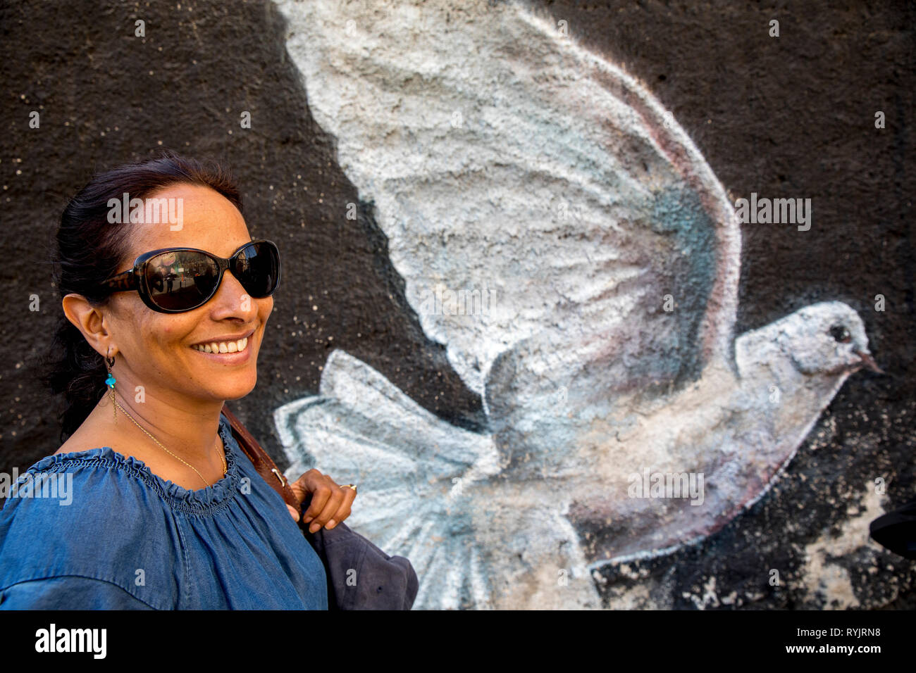 Frau stand vor einer bemalten Wand in Palermo, Sizilien (Italien). Stockfoto