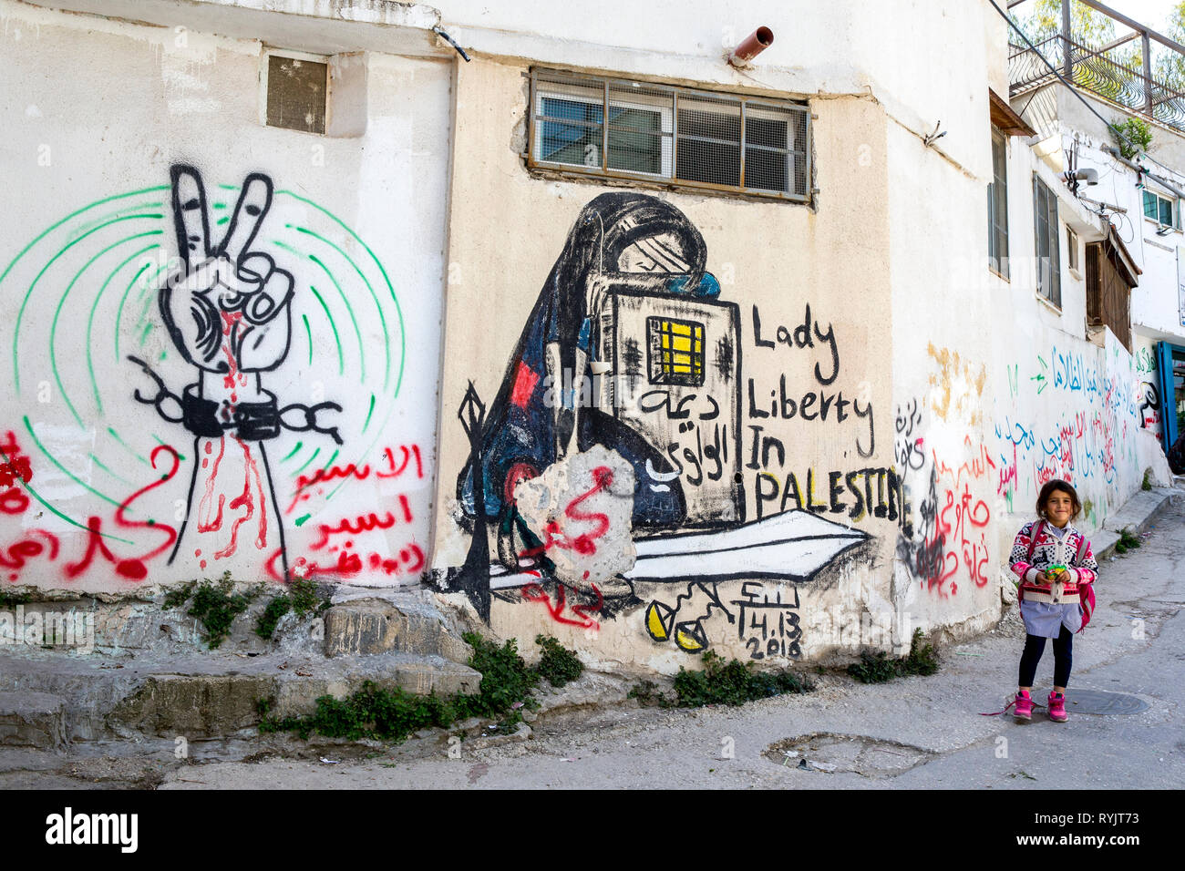 Schulmädchen in der Nähe von eine markierte Wand in Jalazone Flüchtlingslager in der Nähe von Ramallah, West Bank, Palästina. Stockfoto