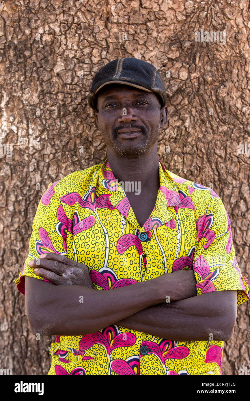 Togolesische Mann, der Vor einen Baum. Stockfoto