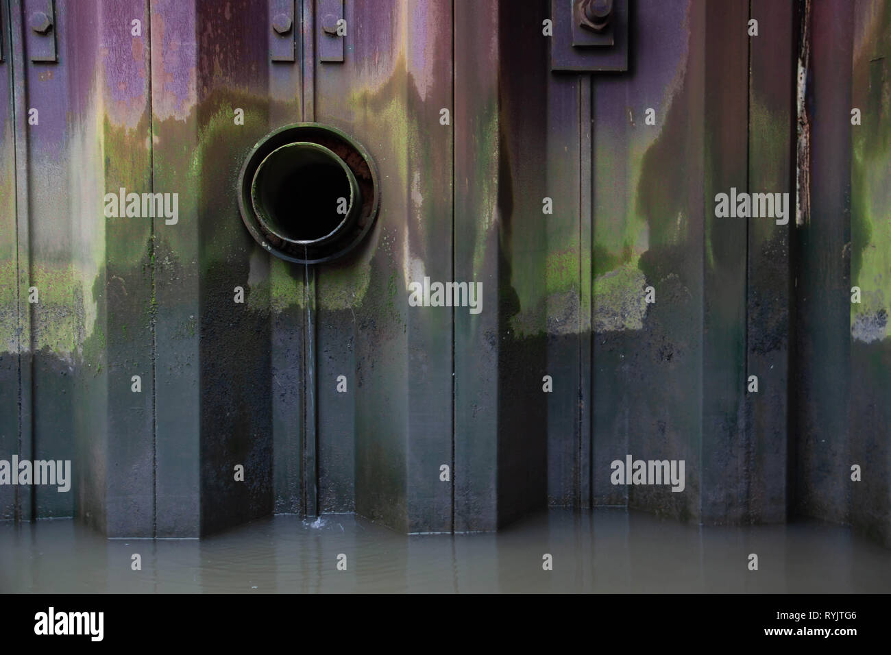 Eine bunte Spundwand im Hafen mit Auslass Stockfoto