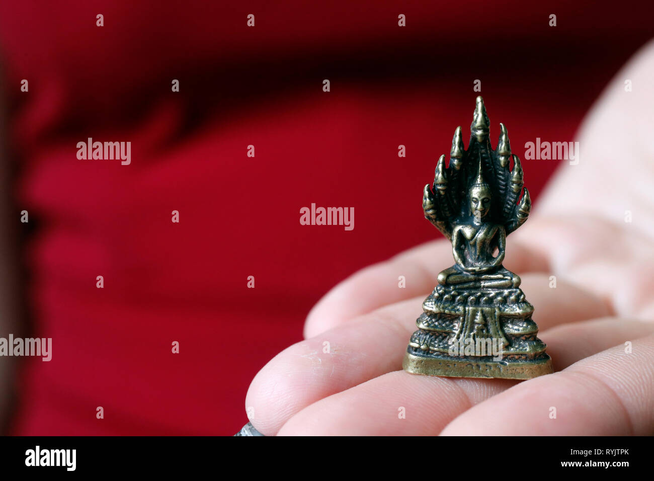 Frau mit einer Miniatur Figur Messing Statue von Buddha mit 7 Köpfen Naga. Ho Chi Minh City. Vietnam. Stockfoto