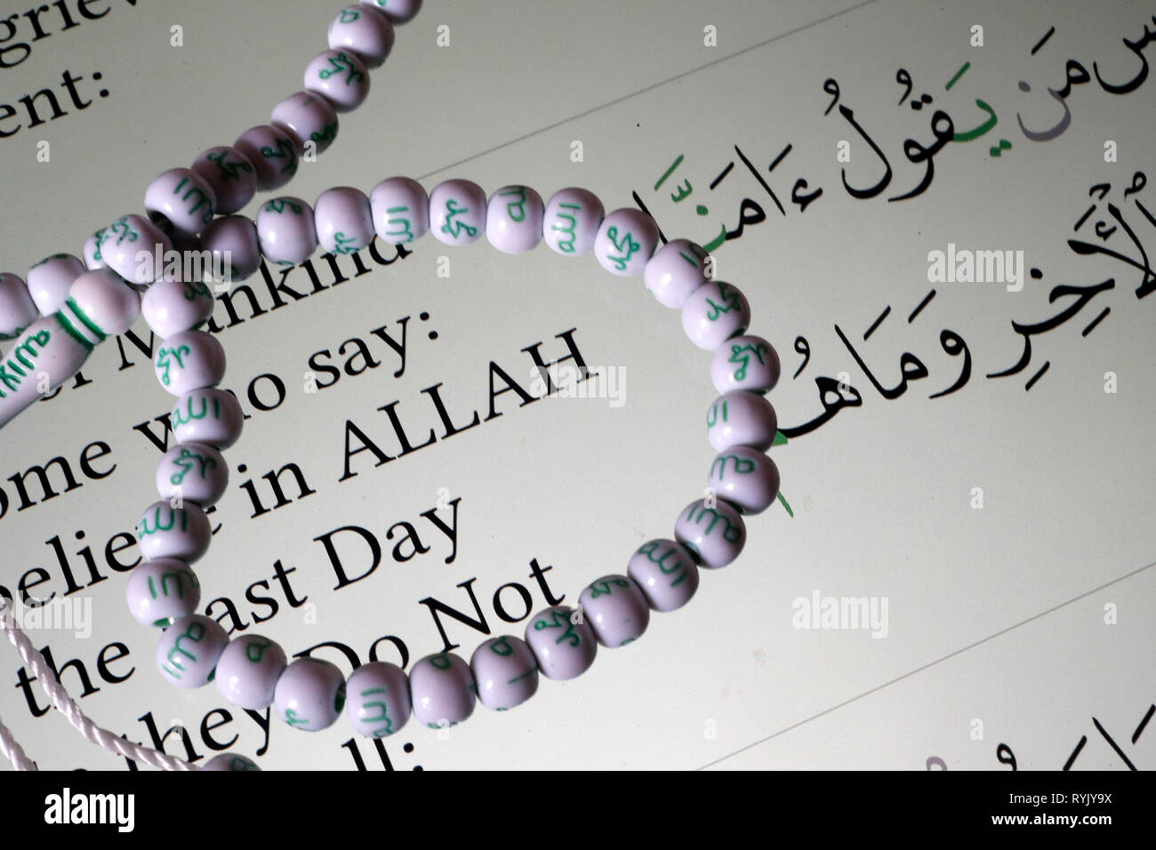 Digitale der Qur'an ein Smartphone und muslimische Gebet Perlen. Englische Übersetzung. Glauben an Allah. Close-up. Stockfoto