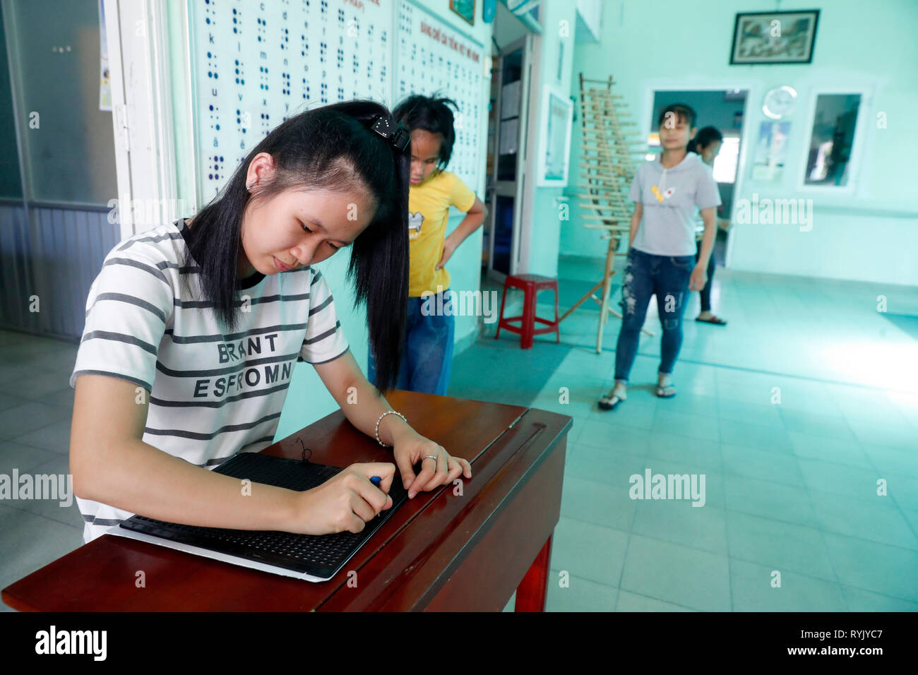 Zentrum für blinde Kinder von Kindern Aktion ausführen. Mädchen schreiben Blindenschrift. Ho Chi Minh City. Vietnam. Stockfoto