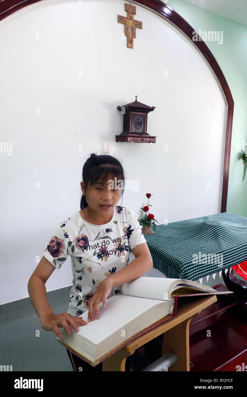 Zentrum für blinde Kinder von Kindern Aktion ausführen. Katholische Kapelle. Blinden Mädchens Lesen eines Braille Version der Bibel. Ho Chi Minh City. Vietnam. Stockfoto