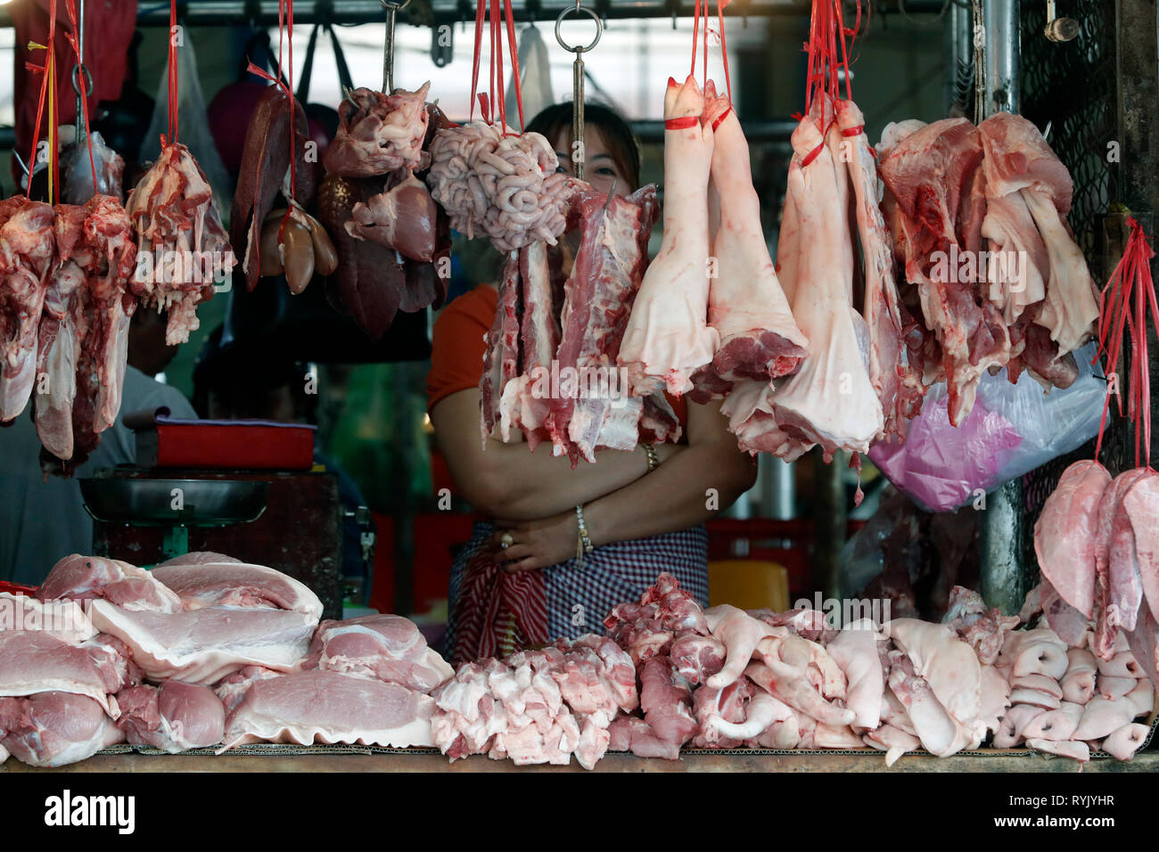 Fleischstücke hängen an Haken an einem traditionellen Markt Metzgerei. Ha Tien. Vietnam. Stockfoto