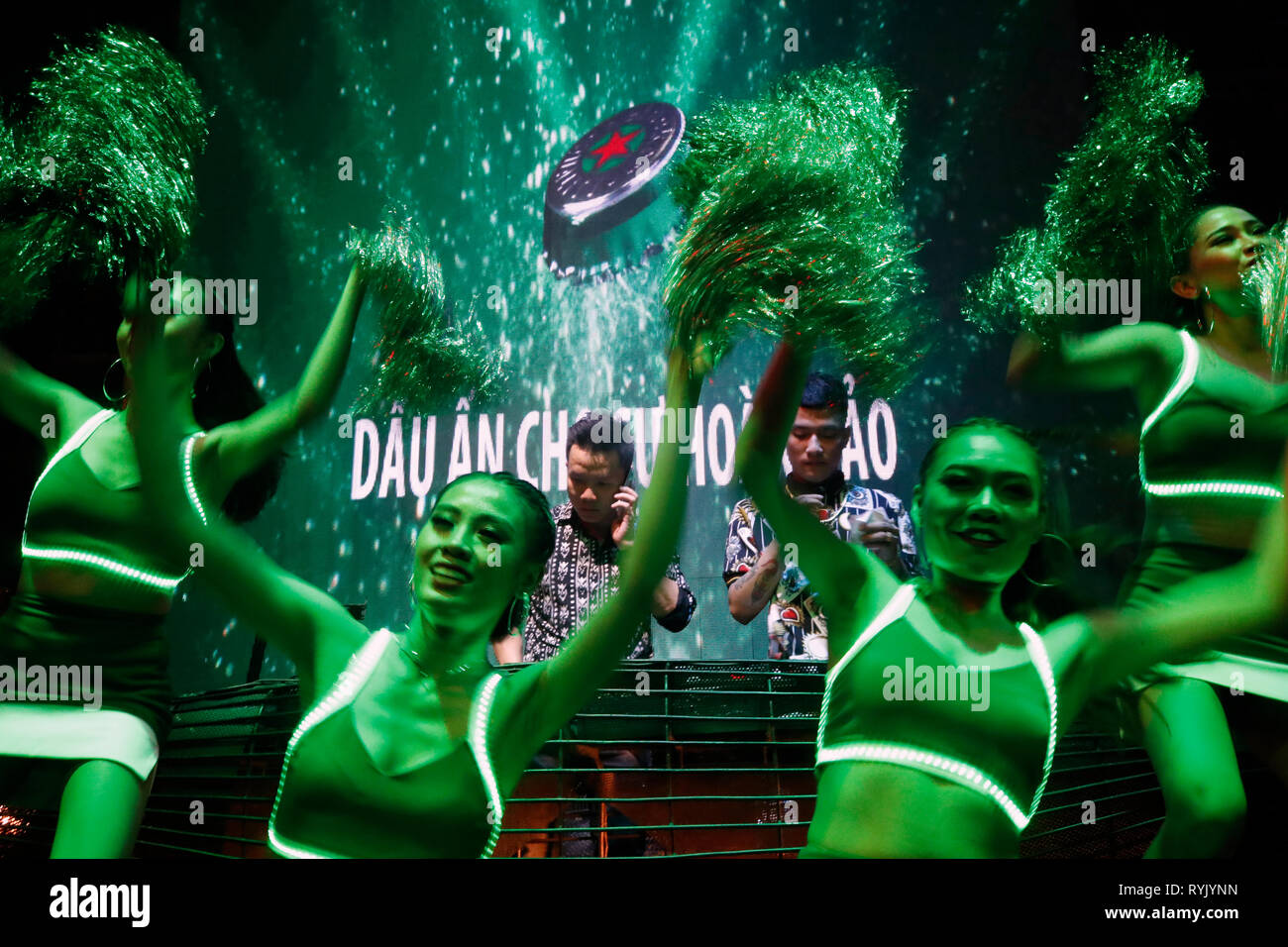 DJ auf der Bühne und Heineken Mädchen gestikulierend zu Gast Tanzen im Nachtclub. Ho Chi Minh City. Vietnam. Stockfoto