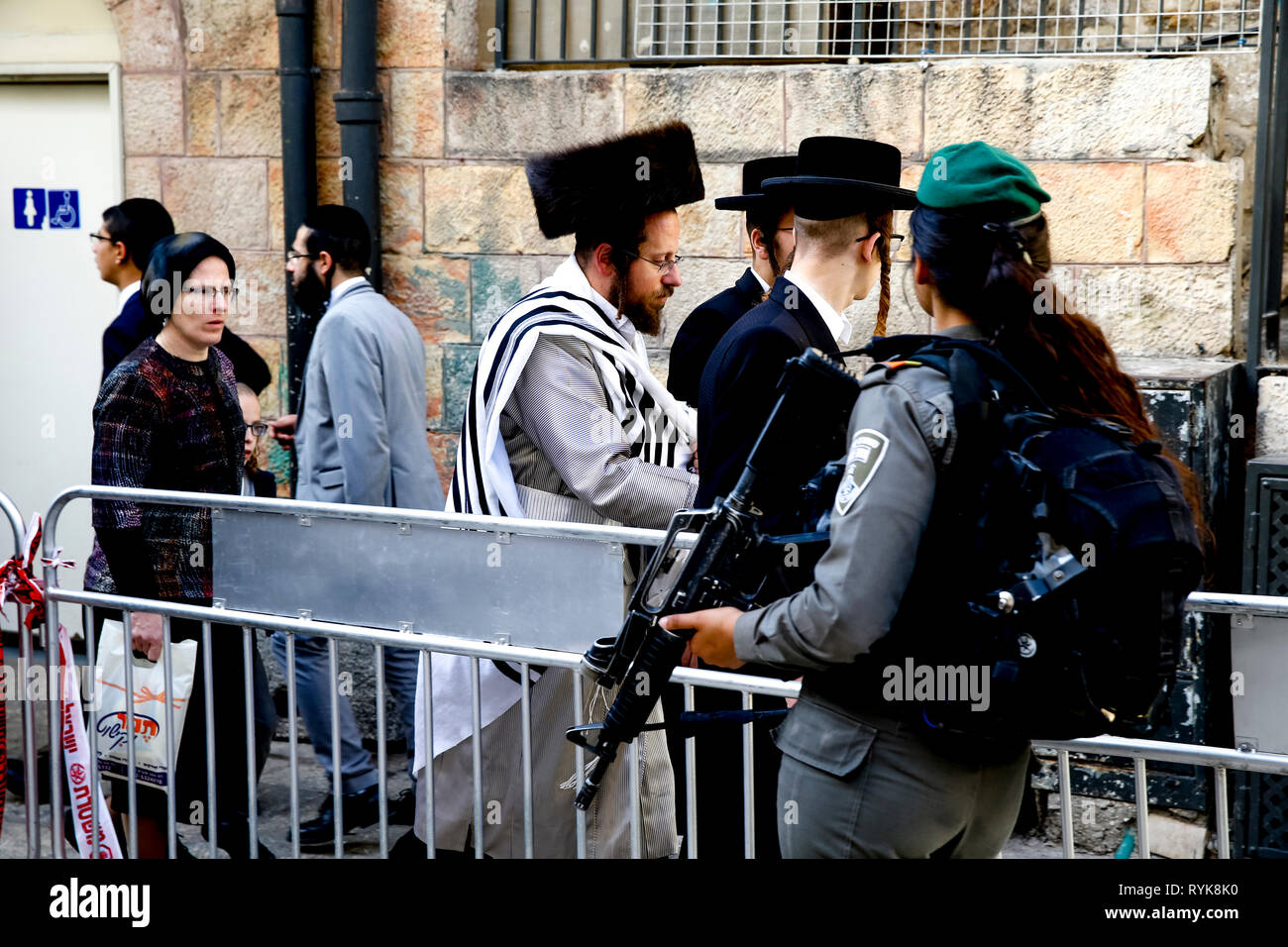 Orthodoxe Juden wandern vorbei an einem Militärkontrollpunkt in Ost Jerusalem, Israel. Stockfoto