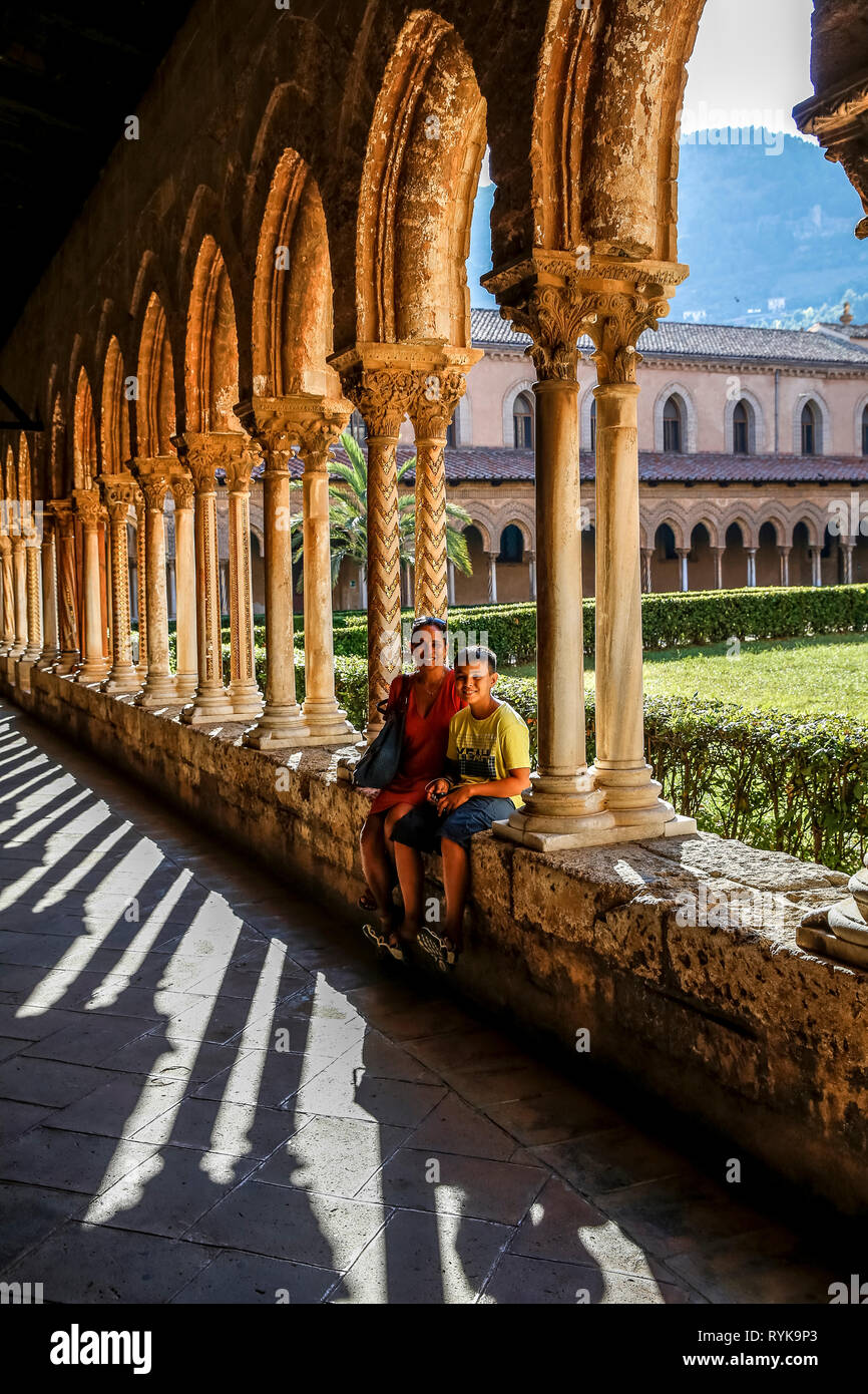 Der 12-jährige Junge sitzt mit seiner Mutter in den Kreuzgang der Kathedrale von Monreale, Sizilien (Italien). Stockfoto