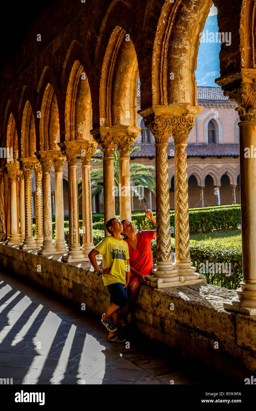 12-jähriger Junge mit seiner Mutter in den Kreuzgang der Kathedrale von Monreale, Sizilien (Italien). Stockfoto