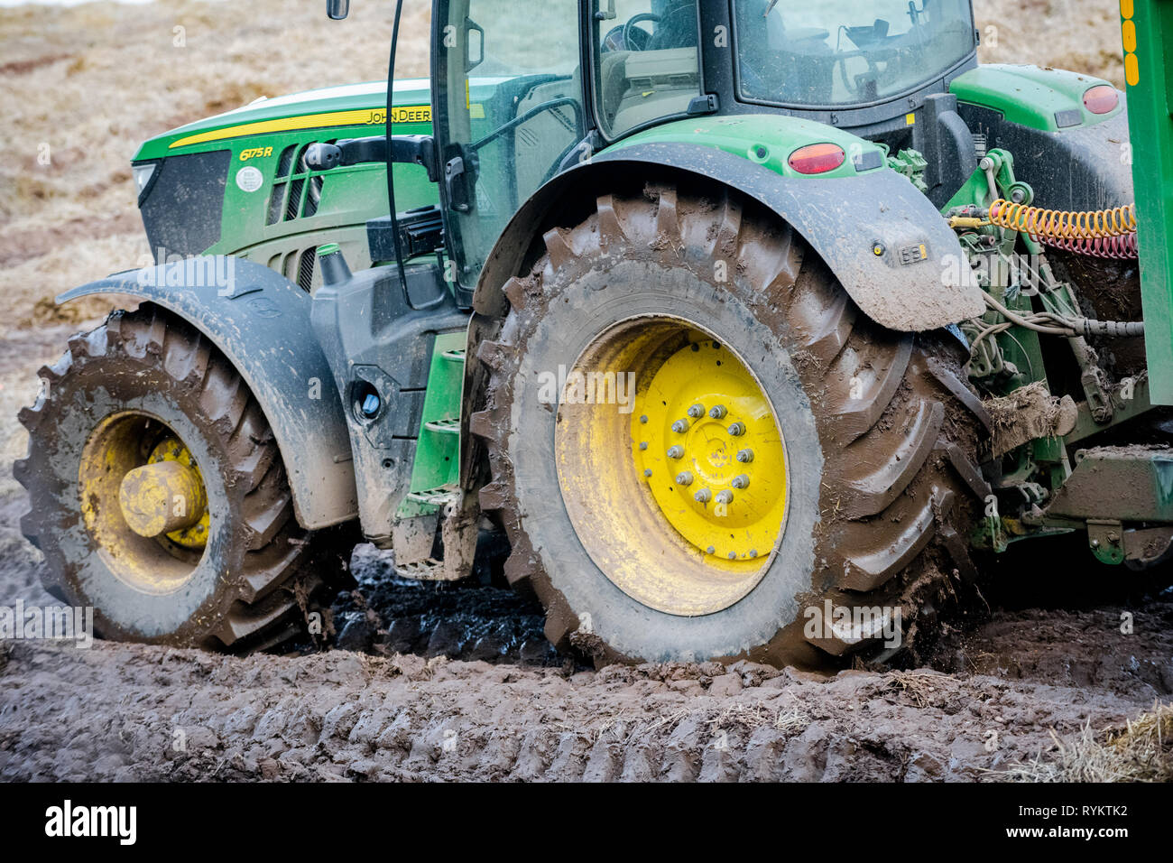 John Deere Traktor in ein schlammiges Feld. Stockfoto