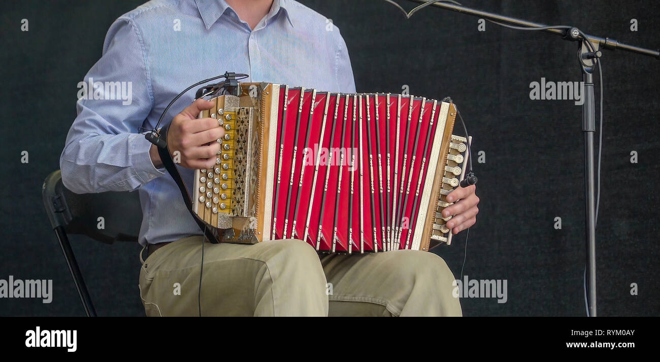 Ein Mann spielt das Akkordeon auf der Bühne seine Finger spielerisch auf der Instrumententafel Stockfoto