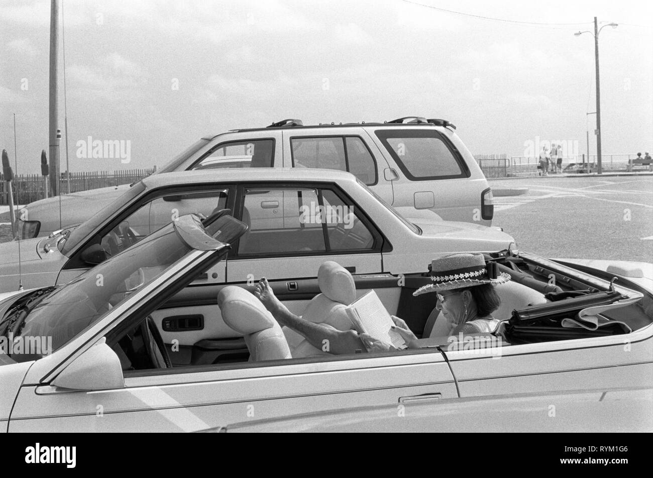 Lake Worth, Florida der 90er Jahre. Frau mit einem Buch in oben offenen Sportwagen See wert USA 1999 HOMER SYKES. Stockfoto