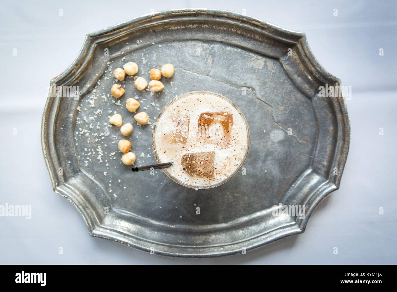 Haselnuss White Russian Cocktail auf einer soliden Metall Tablett mit geriebenen Haselnüssen Stockfoto