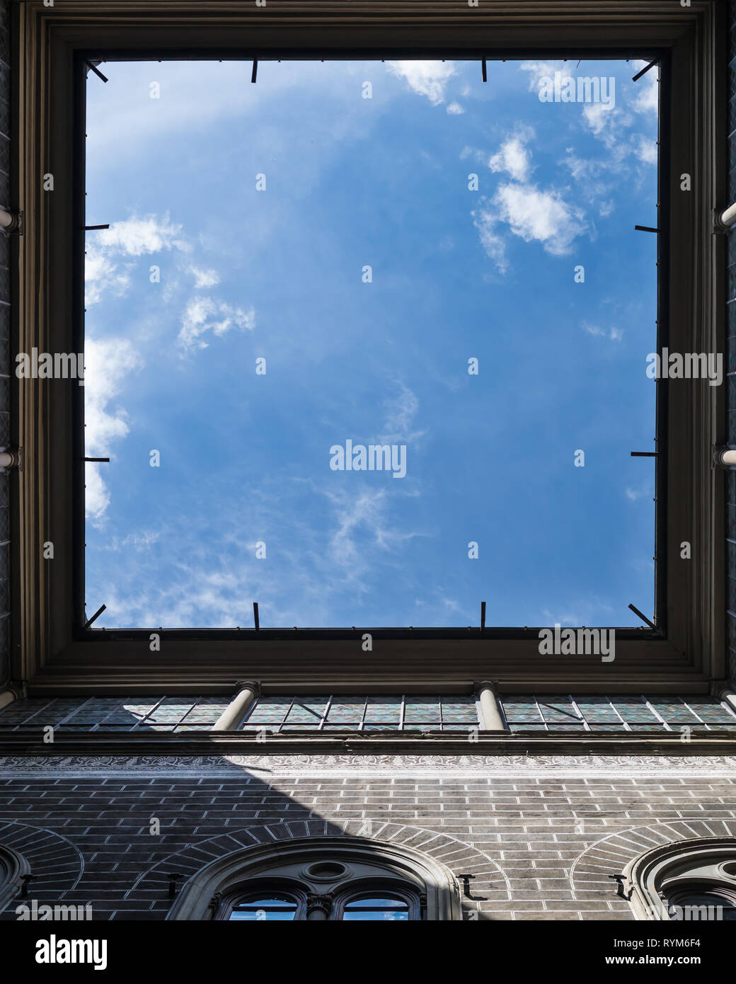 Fenster in den Himmel. Blick hinauf zum Hof des Vintage House in Florenz, Italien. Sehr interessante Winkel. Quadratischen Rahmen mit fallenden Sonnenstrahlen. Stockfoto