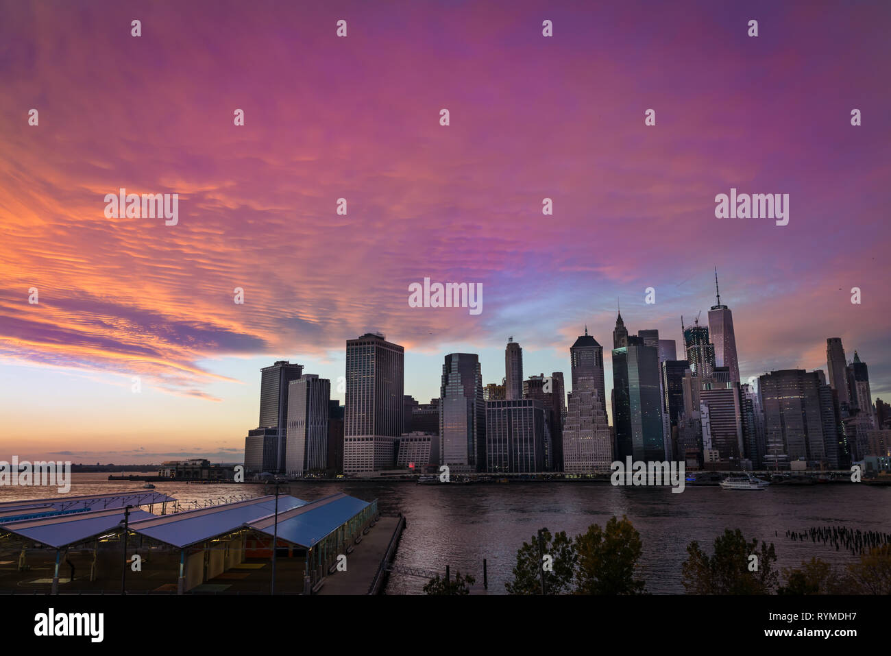 City Downtown auf dem Hintergrund der erstaunlichen Sonnenuntergang mit Blau und Violett. Blick von Brooklyn auf Manhattan Wolkenkratzer in Abend mal in New York, USA. Stockfoto